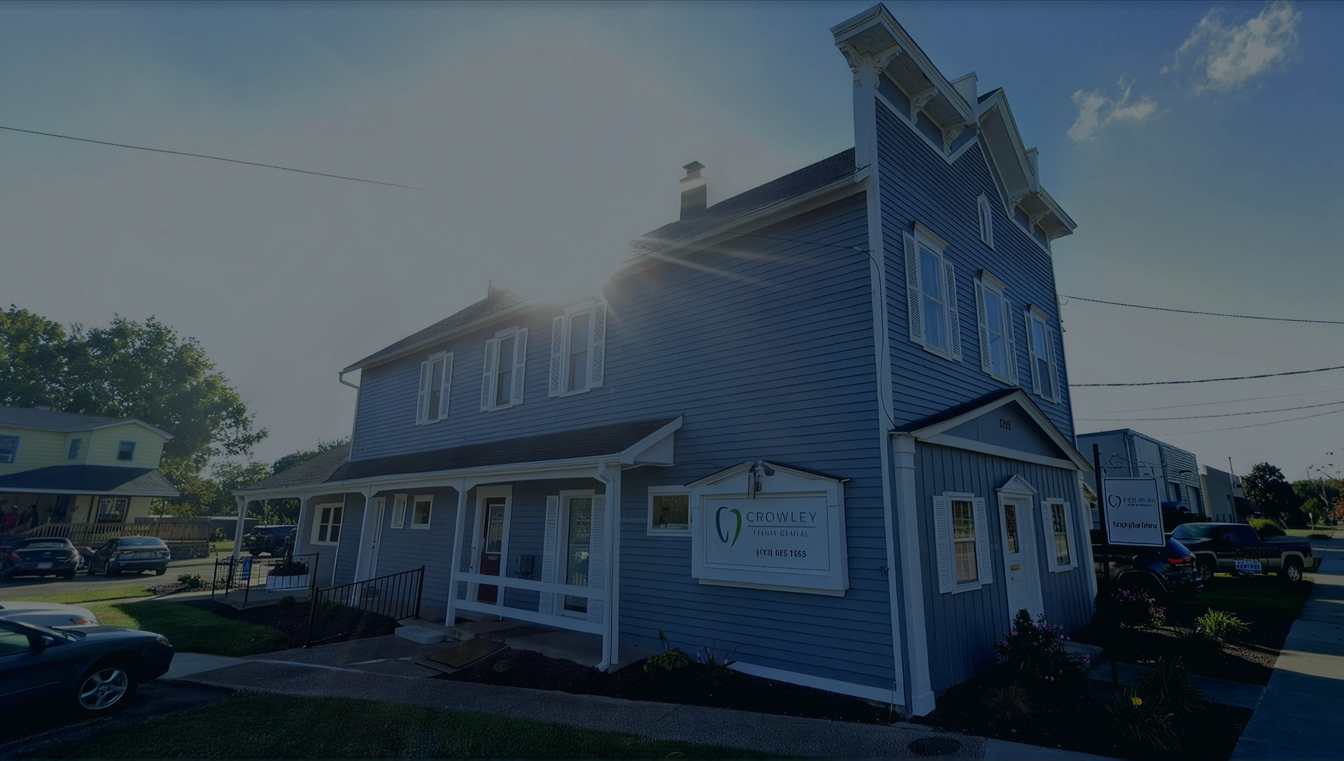 Exterior view of Crowley Family Dental Group building with blue siding, white trim, and a front entrance.